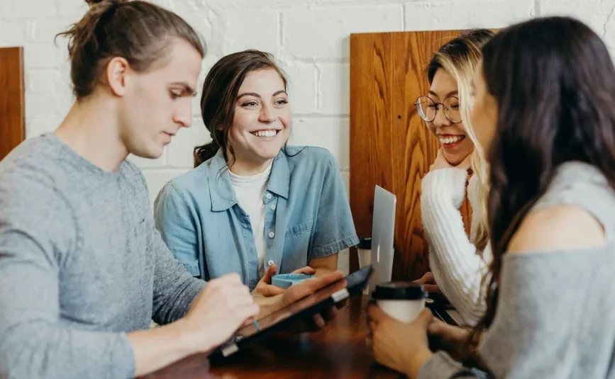 Group of young people having a discussion around a laptop