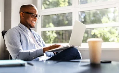 Smiling business man looking at a laptop