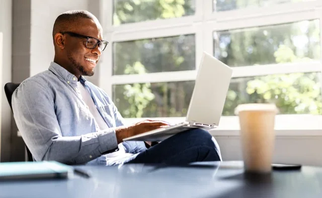 Smiling business man looking at a laptop