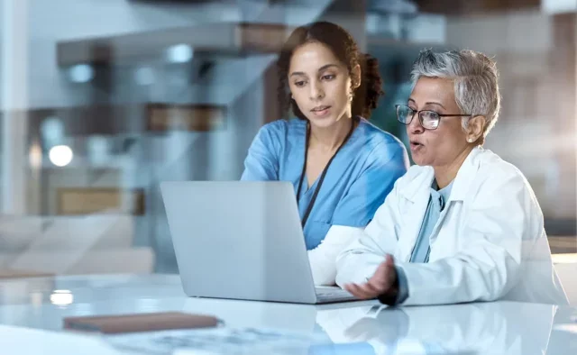 Two female doctors looking at a laptop