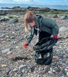 Woman litter picking on a beach