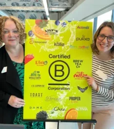 Two AG team members holding a 'B Corp Certified' sign